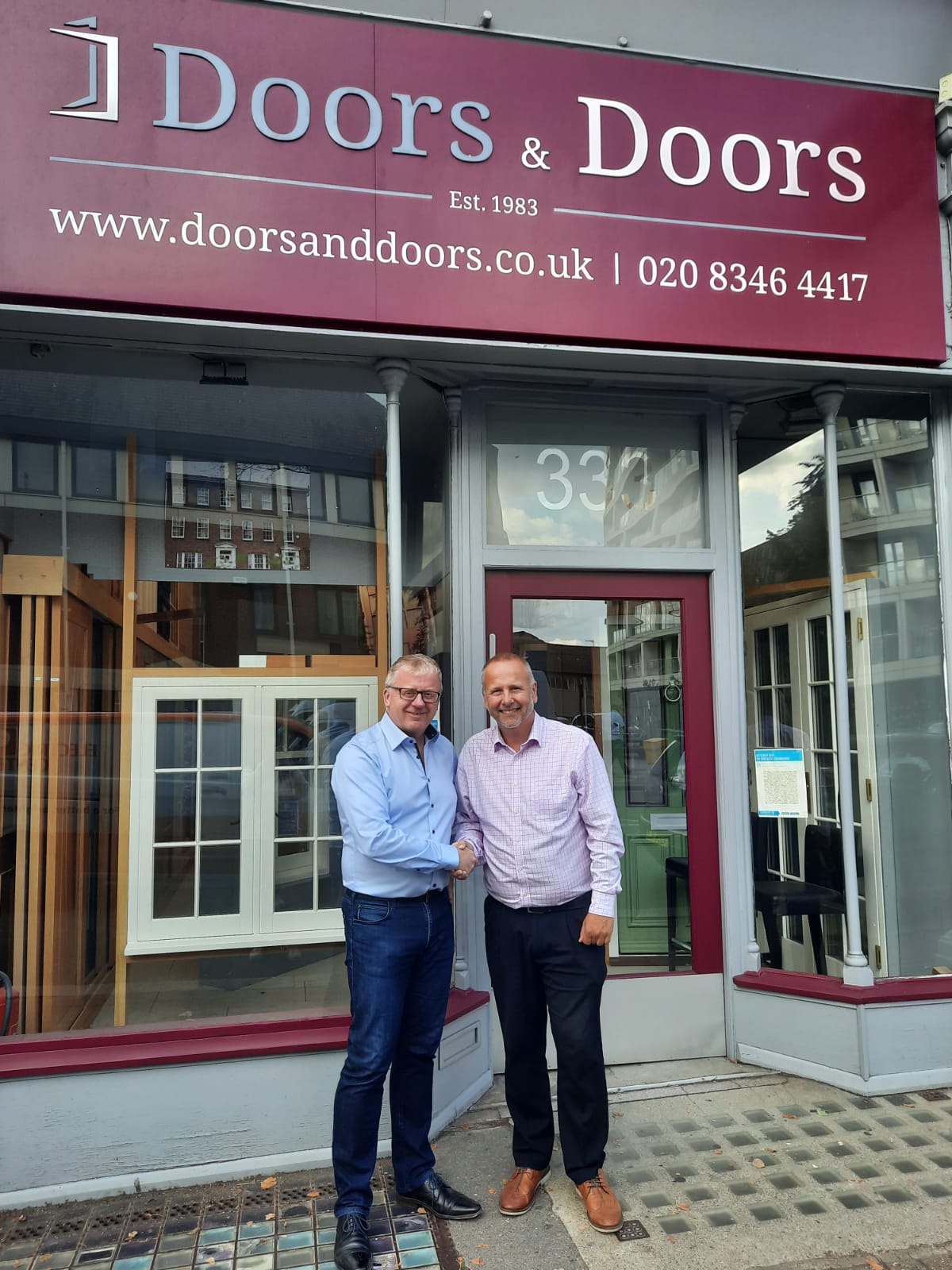 Paul and Dunc shaking hands outside showroom