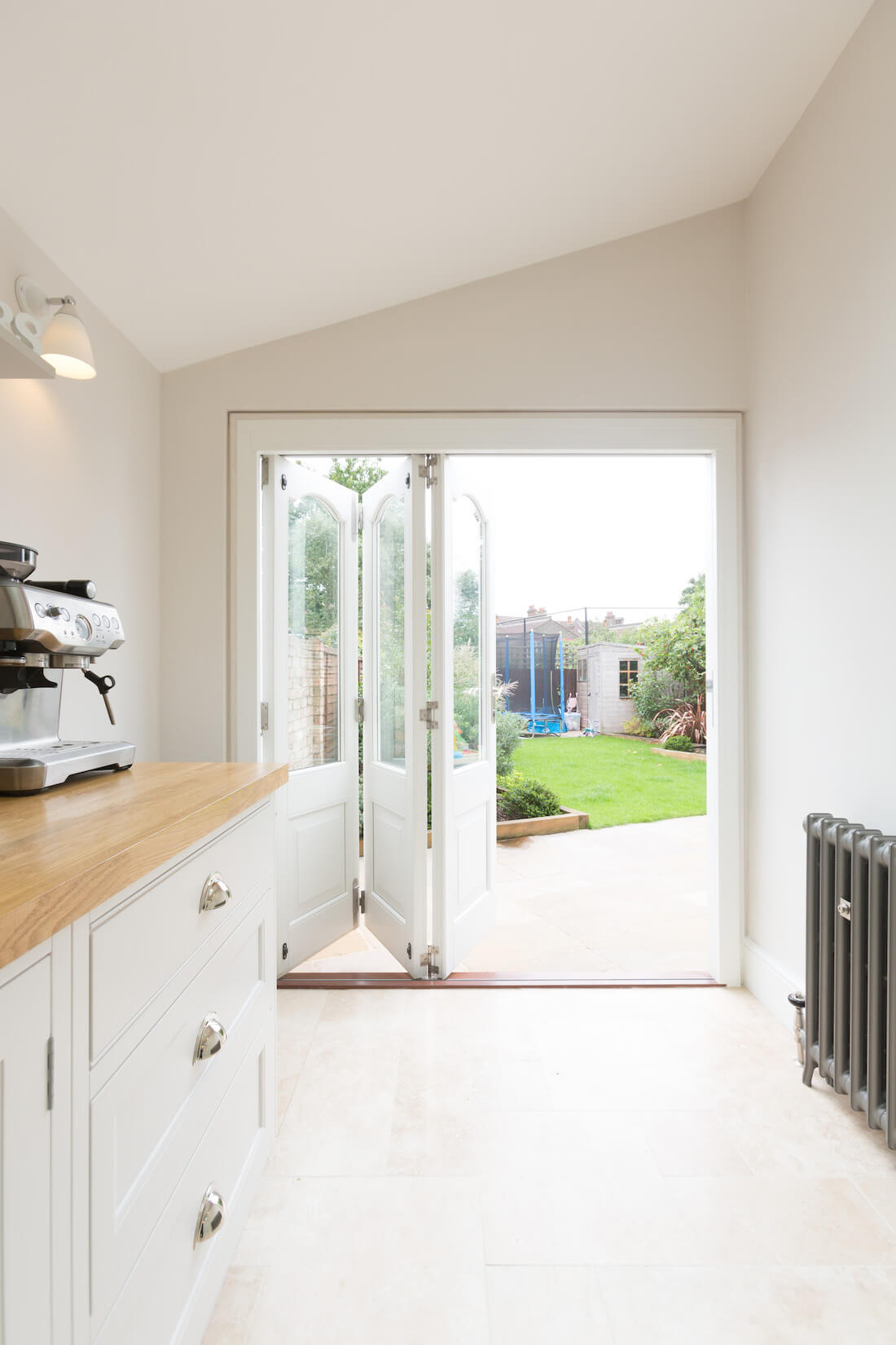Opened white bi-fold doors showing residential garden